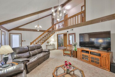Carpeted living room with high vaulted ceiling, a 