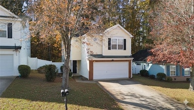 Traditional-style house with driveway, a garage, brick siding, and a gate