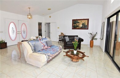 Formal living area with owners suite doors in back of photo