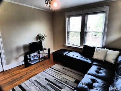 Living area with wood finished floors and ornamental molding