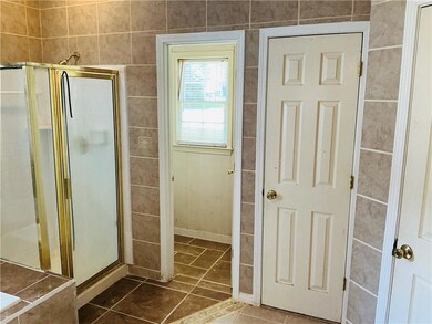 Full bath featuring a stall shower and tile patterned flooring