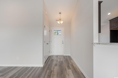 Foyer entrance with wood finished floors and recessed lighting