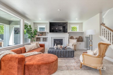 Living room with a glass covered fireplace, stairway, and recessed lighting