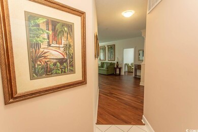 Hall featuring ornamental molding, tile patterned 