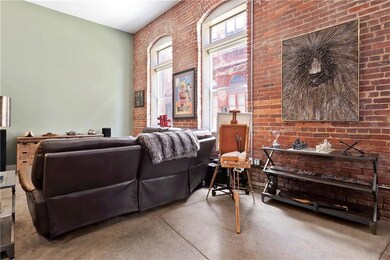 Living area featuring concrete flooring and brick 