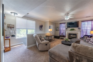 The living room has a gas fireplace. Lighted ceiling fan. Neutral decor and is open to kitchen area