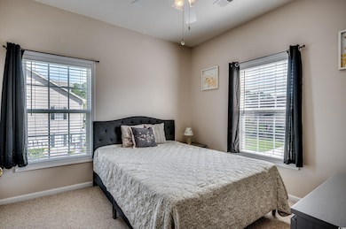 Bedroom featuring multiple windows, light colored 