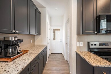 Kitchen with black microwave, decorative backspla