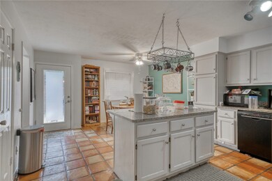 Kitchen with black appliances, a kitchen island, c