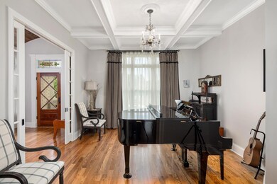 The music room or office has coffered ceilings and  2 set of French Glass Doors with custom glass door knobs.
