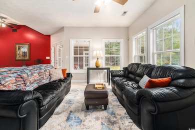 Living area featuring ceiling fan and tile patterned flooring