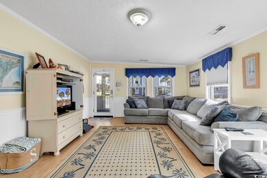Living room featuring ornamental molding, lofted c