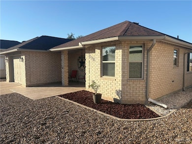 Ranch-style house with a garage, brick siding, a patio area, and driveway