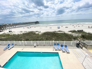 Community pool with a patio, a water view, and a b
