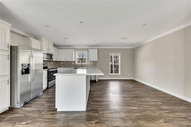 Kitchen featuring ornamental molding, white cabine