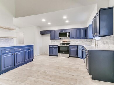 Kitchen featuring backsplash, light countertops, l