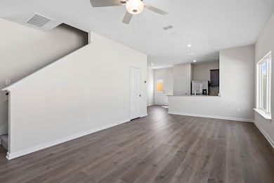 Unfurnished living room with dark wood-style flooring, plenty of natural light, ceiling fan, and recessed lighting