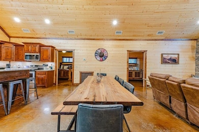 Dining space featuring finished concrete flooring, visible vents, and wood ceiling
