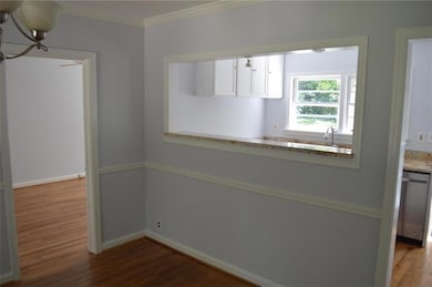 Kitchen with wood finished floors, crown molding, 
