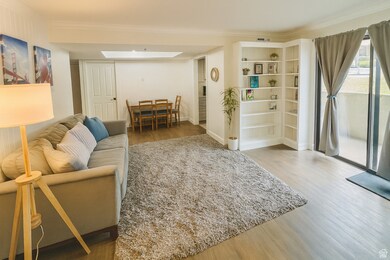 Living area featuring light wood-style flooring and crown molding