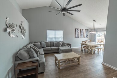 Living room featuring ceiling fan, dark hardwood /