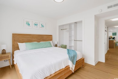 Bedroom featuring light wood finished floors and a closet