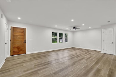 Spare room with recessed lighting, a ceiling fan, light wood-style floors, and baseboards