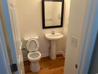 Half bath featuring toilet, wood finished floors, and baseboards