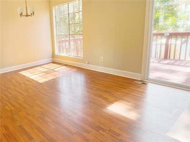 Spare room with a chandelier, baseboards, and wood finished floors
