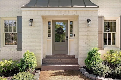 Entrance to property featuring a standing seam roof, brick siding, and a metal roof