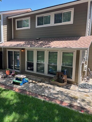 Back of property with roof with shingles and a patio area