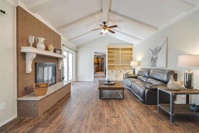Living room with a brick fireplace, vaulted ceilin