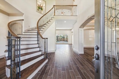 Beautiful view from the front doors.  Look at the rich, wood like tile that guides you throughout the home.  Not the beautiful curved stairs.