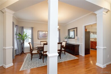 Dining area with light hardwood floors and crown m