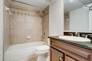 En suite bathroom with granite counter.