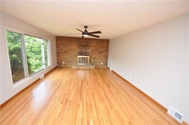 FORMAL LIVING ROOM WITH BEAUTIFUL HARDWOOD FLOORS, STONE FIREPLACE, LARGE WINDOW AND FRESHLY PAINTED WALLS AND NEWER CEILING FAN. THIS LIVING ROOM IS LARGE AND BRIGHT AND OPENS INTO THE DINING ROOM.