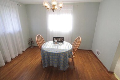 Dining room features exposed wood floors.