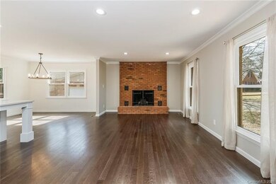 The large Family Room features new wood floors, Full Brick Fireplace, and is open to the kitchen