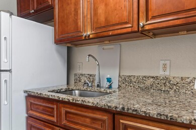 Kitchen with white refrigerator, sink, and light s