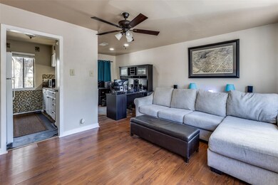 Living area featuring baseboards, a ceiling fan, and wood finished floors
