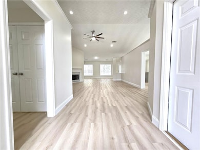 Unfurnished living room featuring a ceiling fan, b
