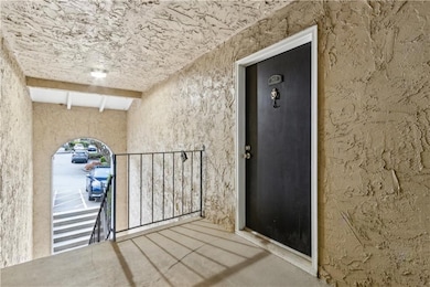 Doorway to property featuring stucco siding