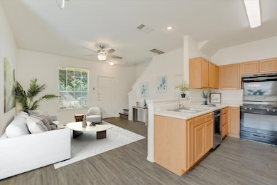 Kitchen featuring light brown cabinets, open floo