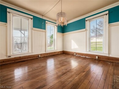 Spare room featuring dark hardwood / wood-style flooring, a chandelier, and ornamental molding