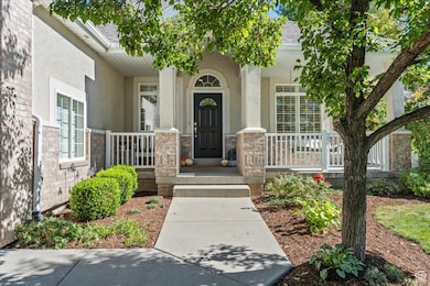 Entrance to property featuring covered porch, stone siding, stucco siding, and a shingled roof