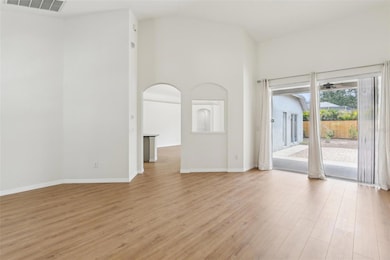 LOOKING FROM FRONT DOOR, ARCHED ENTRY TO KITCHEN, DINETTE AND FAMILY ROOM