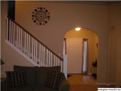 Arch doorway with hardwood floors off the foyer le