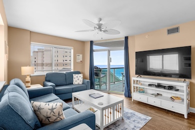Living area featuring wood finished floors, ceiling fan, and a wall of windows