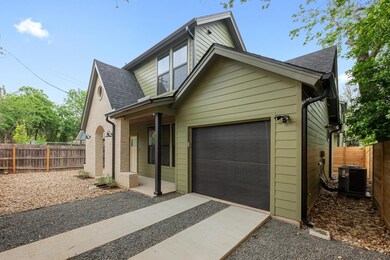 View of front of home with fence, driveway, a gar