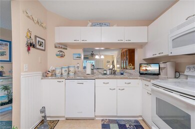 Kitchen featuring white cabinetry, sink, white app